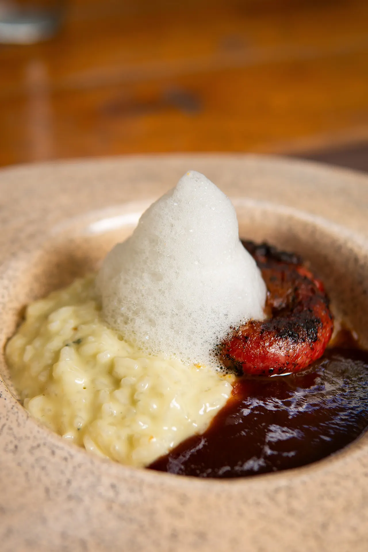 Risoto autoral com espuma e redução, servido no Ollivia