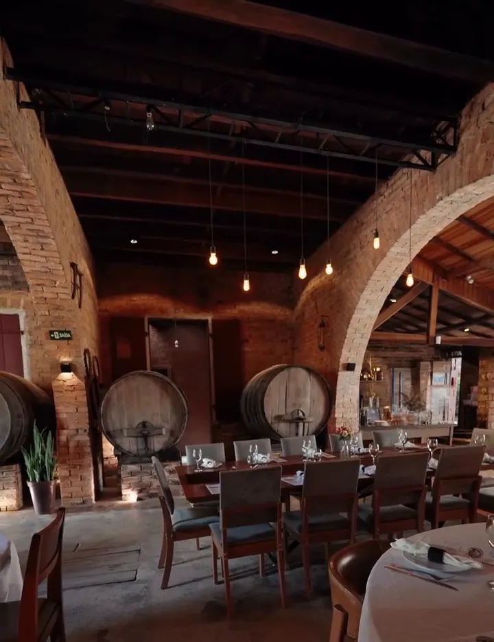 Salão com arcos de tijolo e barris de vinho no Ollivia